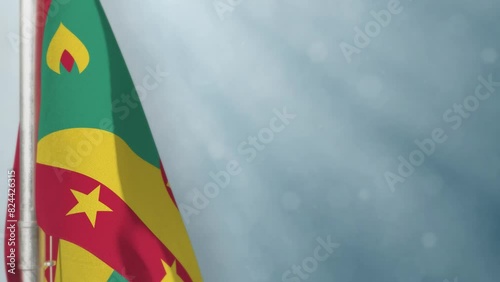 Waving Grenada flag on light blue bokeh bg photo