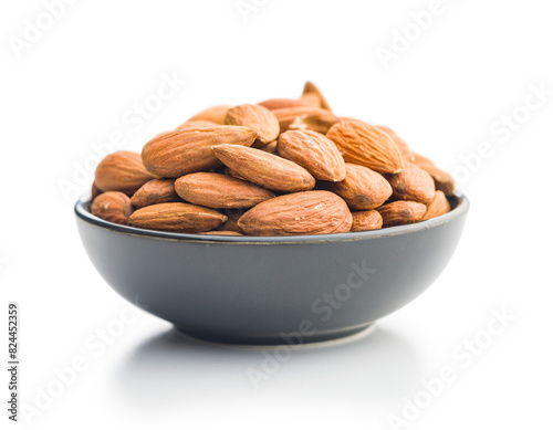 Peeled almond nuts in bowl isolated on white background.