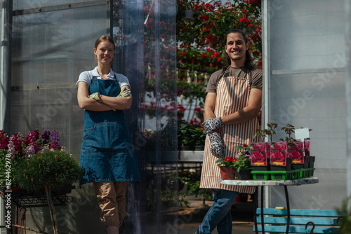 Portrait of gardeners with plants at greenhouse