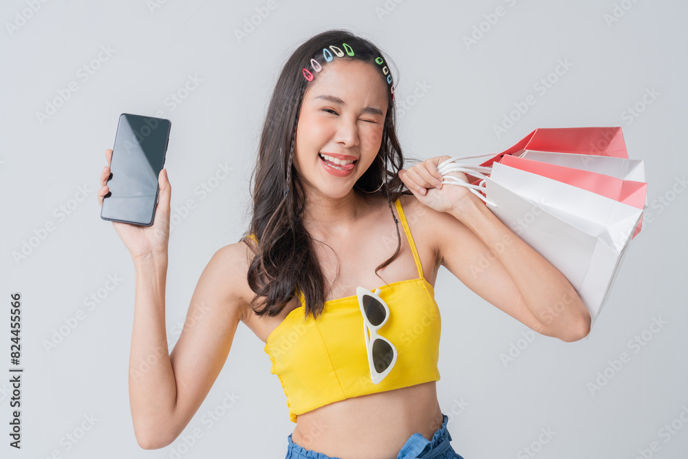 Asian happy female woman girl holds colourful shopping packages standing on plain background studio shot, Close up Portrait young beautiful attractive girl smiling hand hold colorful shopping bag Asian happy female woman girl holds colourful shopping packages standing on plain background studio shot, Close up Portrait young beautiful attractive girl smiling hand hold colorful shopping bag