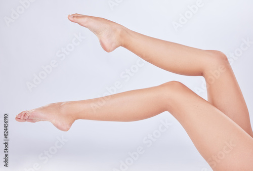 Closeup  legs and woman with skincare  dermatology and fitness on white studio background. Person  model and human with beauty  cosmetics and smooth with shine  clear skin and glowing with wellness