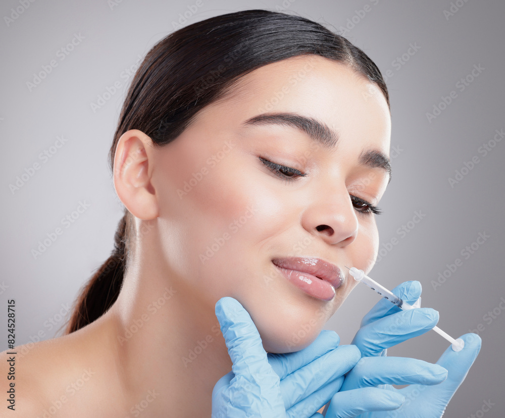 Hands, injection and woman with plastic surgery lip filler for beauty on studio background. Botox, syringe and face lift process in clinic with patient closeup or antiaging cosmetics treatment Hands, injection and woman with plastic surgery lip filler for beauty on studio background. Botox, syringe and face lift process in clinic with patient closeup or antiaging cosmetics treatment