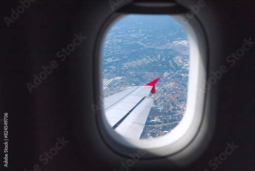 Clear blue sky with fluffy ornamental cumulus clouds, panoramic view from an airplane, wing close-up. © paul