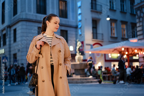 Photography Portrait of beautiful caucasian woman wearing coat is walking by night Wien street