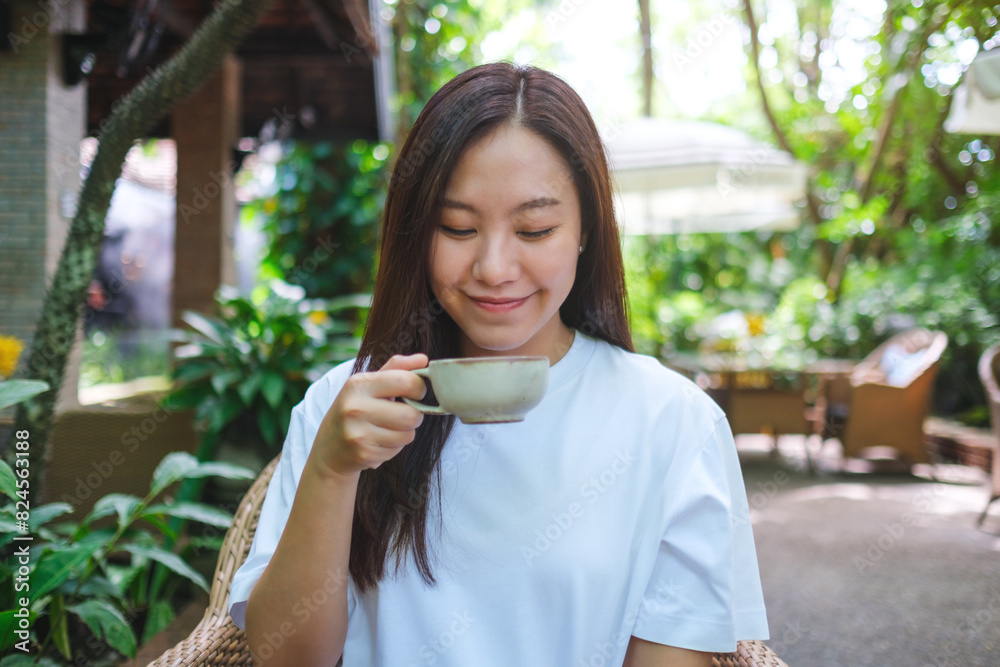 Portrait image of a young woman drinking coffee in the outdoors cafe Portrait image of a young woman drinking coffee in the outdoors cafe