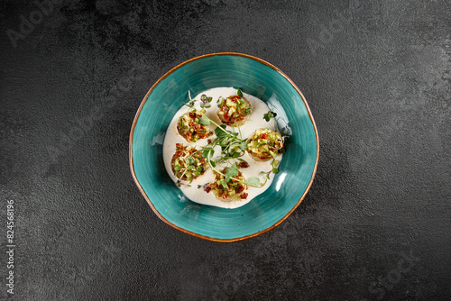 Scallops in a creamy mousse with tomato salsa, delicately plated in a turquoise dish
