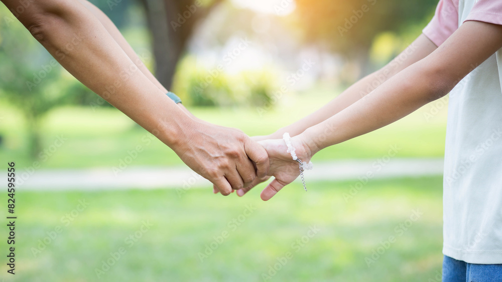 Mom and her child holding hands in park, closeup Mom and her child holding hands in park, closeup