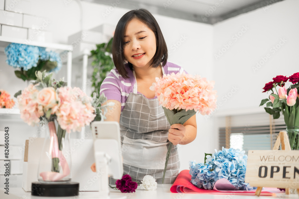 A couple of Asian entrepreneurs using their smartphones to sell flowers online. A couple of Asian entrepreneurs using their smartphones to sell flowers online.