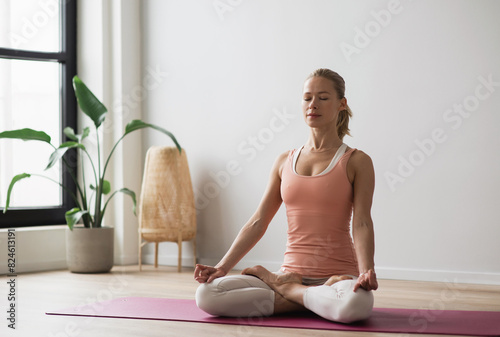 Woman practicing yoga, doing relaxation exercises, meditating at home. Meditation, yoga, balance, mindfulness, workout, relaxation, healthy lifestyle concept