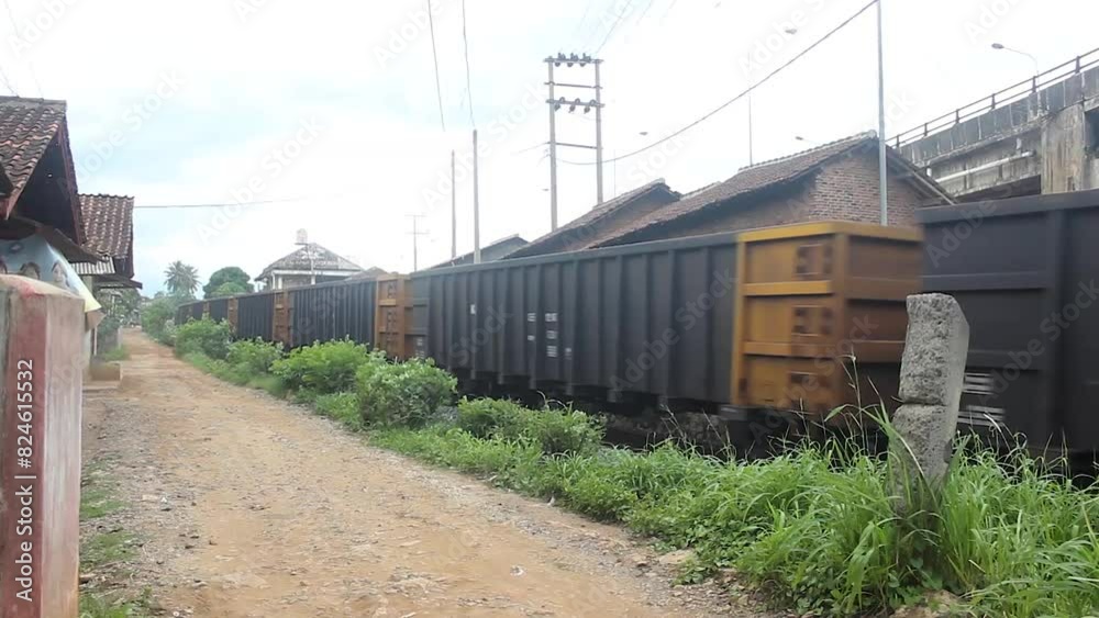 A coal train crosses the railway crossing in the middle of a residential area. A coal train crosses the railway crossing in the middle of a residential area.