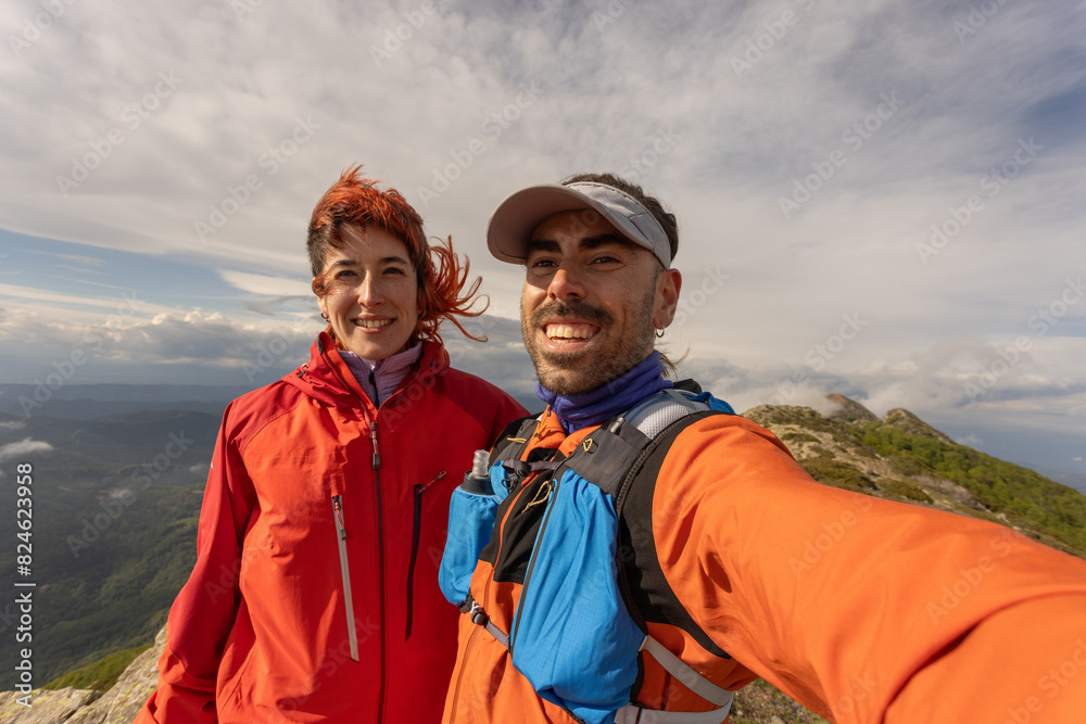 A man and a woman are smiling for a picture on a mountain A man and a woman are smiling for a picture on a mountain