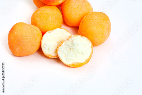  Apricots, retro old-fashioned candy. Apricot sweets with one open sweet showing the spongy inside. Isolated on white with copy space. Apricot mallow candy