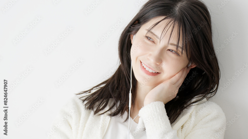 ベッドで音楽を聞く女性 ベッドで音楽を聞く女性