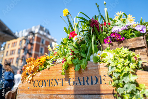 Photography Old fashioned wooden barrow with boxes of flowers, outside the stores of the world famous Covent Garden Market, London