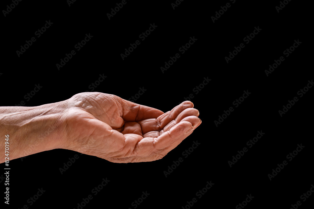 Elderly woman, wrinkled hand palm reaching out forward. Old lady arms. Old man hand on a black background. Old lady's hand with open palm. Elderly lady is waiting for help. Elderly, aging concept
