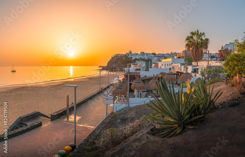 Obraz na płótnie Bask in the warm glow of sunset at Morro Jable, Fuerteventura, where golden sands meet tranquil Atlantic waters w salonie