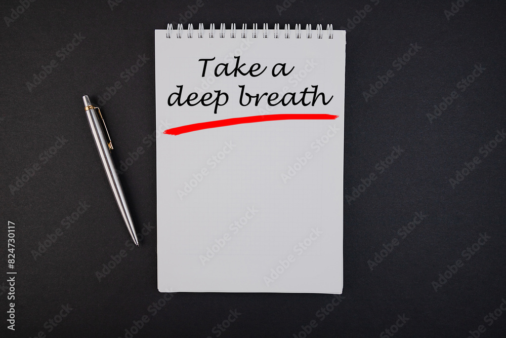 Lettering concept. Take a deep breath in a notebook with a laptop and pen. Lettering concept. Take a deep breath in a notebook with a laptop and pen.