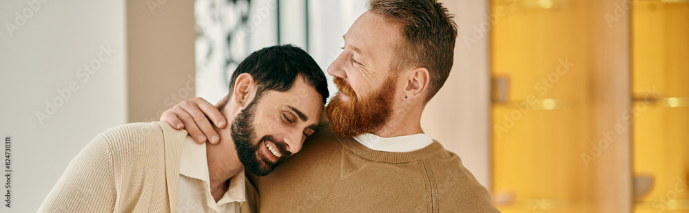 Fototapeta premium Two men hug each other warmly, expressing love and affection in front of a vibrant yellow wall.