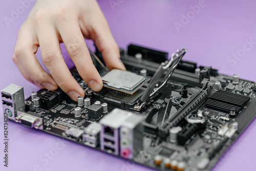 system administrator installing central processor unit into motherboard, assembling PC of different accessories or components, close-up view of hands, computer repair and maintenance concept © Anton Pentegov