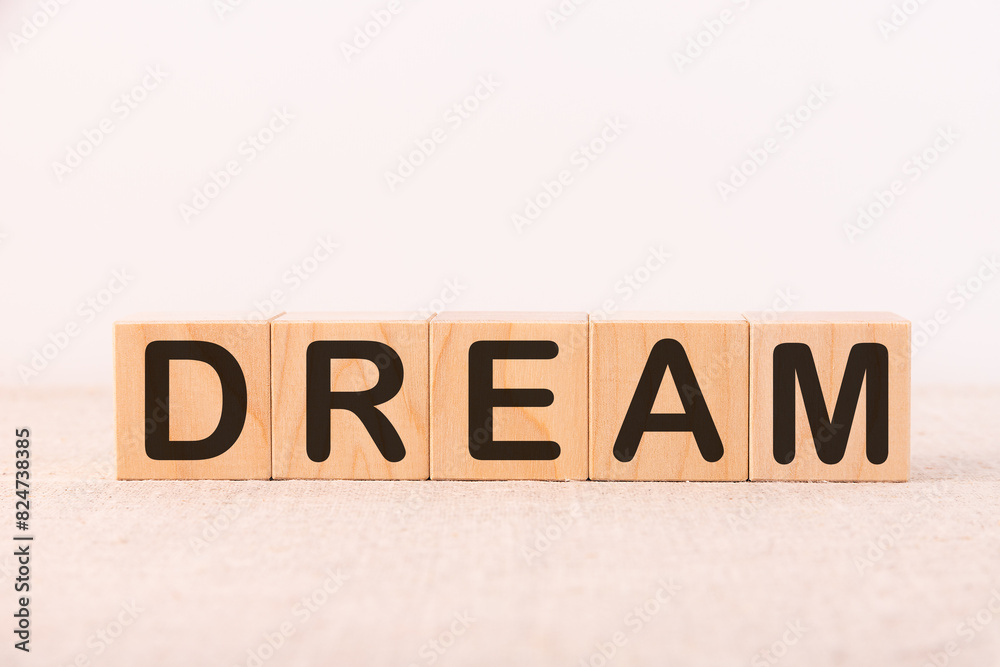 Fototapeta premium Word Dream is written on wooden blocks on a light background.