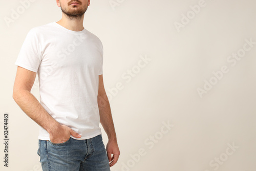 A young guy in a white T-shirt on a light background