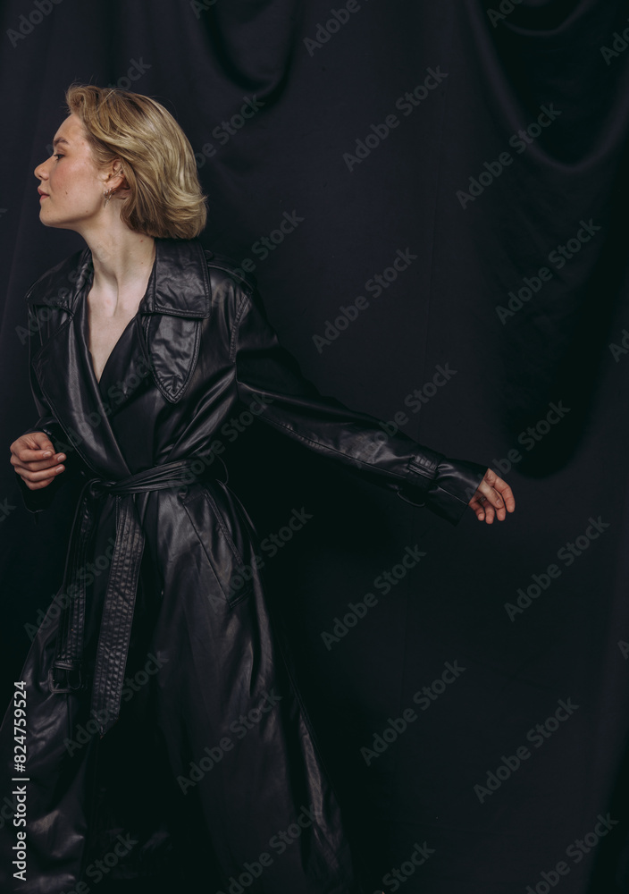 Stylish fashion portraits of a beautiful girl in a cape with a short haircut and a slim figure