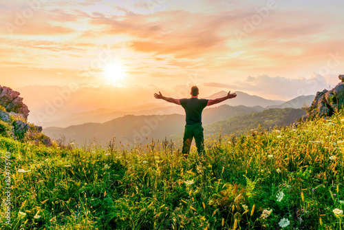 happy man watching amazing highland evening sunset, person delight with nature landscape