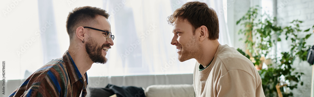 Fototapeta premium Two men, a loving gay couple, stand side by side in a designer workshop, collaborating on trendy attire.
