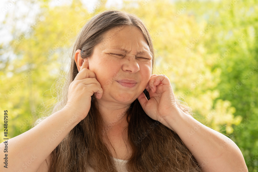 caucasian mature woman holds painful ear, hearing loss, face close-up, medical concept, hearing control, middle ear inflammation, otitis media caucasian mature woman holds painful ear, hearing loss, face close-up, medical concept, hearing control, middle ear inflammation, otitis media