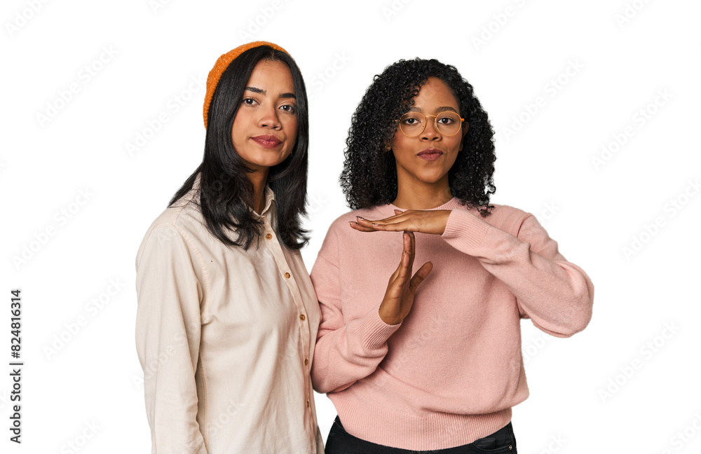 Young Latin friends together in studio showing a timeout gesture. Young Latin friends together in studio showing a timeout gesture.