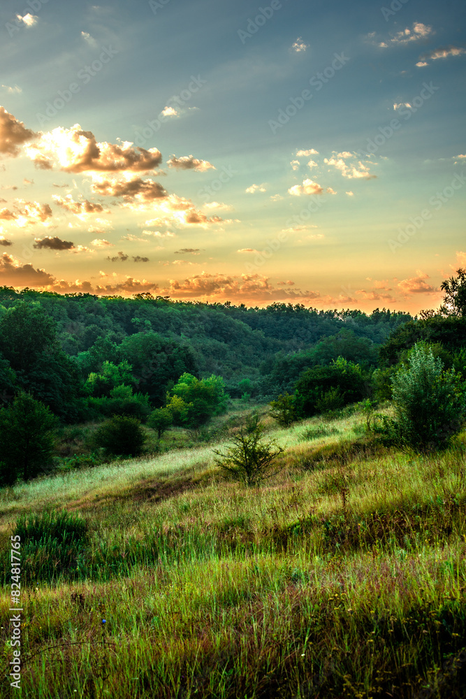 Sunrise and orange sky . Beautiful sunlights . Clouds over the forest . Green grass and trees . Summer morning . Golden hour . Sun over the forest . Lights in forest Sunrise and orange sky . Beautiful sunlights . Clouds over the forest . Green grass and trees . Summer morning . Golden hour . Sun over the forest . Lights in forest