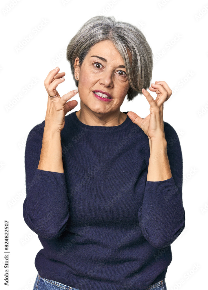 Caucasian mid-age female on studio background upset screaming with tense hands.