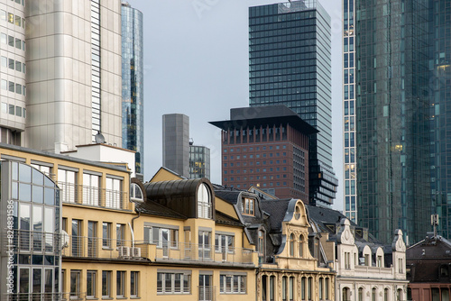 Kontrast zwischen historischer Architektur und modernen Wolkenkratzern in einem urbanen Geschäftsviertel bei bewölktem Himmel