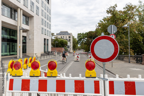 Straßensperrung mit Absperrung und Verkehrsschildern in einer urbanen Umgebung
 photo