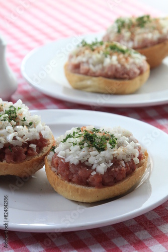 mettbrötchen with onions on wooden table