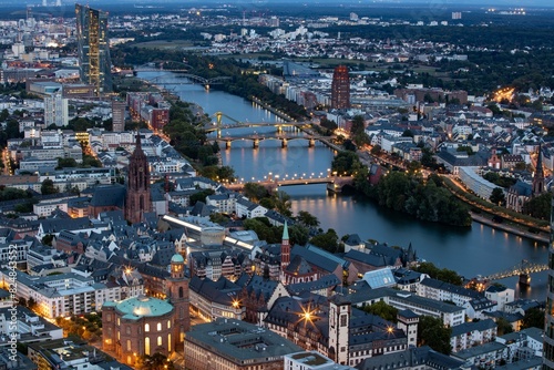 Luftaufnahme der Frankfurter Innenstadt mit dem Main und beleuchteten Brücken während der blauen Stunde am Abend