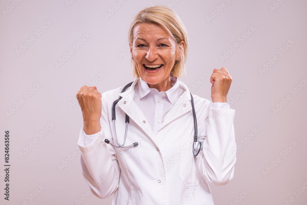 Portrait of excited mature female doctor gesturing on gray background. Portrait of excited mature female doctor gesturing on gray background.