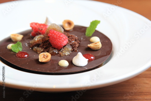 
Chocolate with raspberry, blackberry, mint, in a white plate