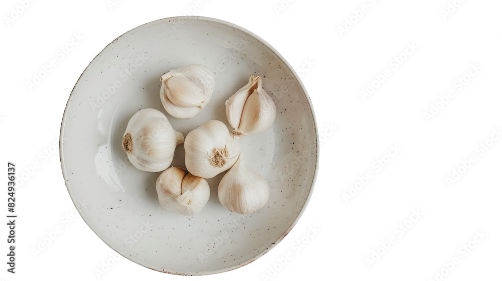 A white bowl on a table filled with garlic cloves A white bowl on a table filled with garlic cloves