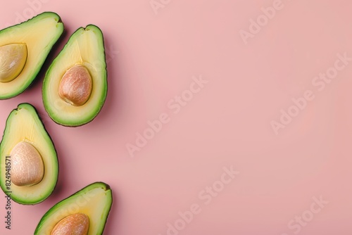 A close up of four avocados on a pink background