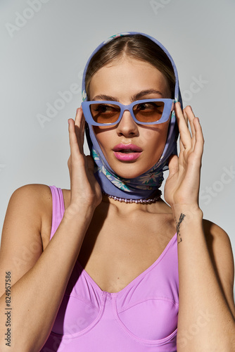 Stylish woman exudes confidence in sunglasses and head scarf. © LIGHTFIELD STUDIOS