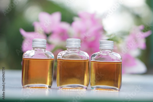 Transparent glass bottles of homemade herbal massage oil. Concept, Thai local wisdom to use fragrant medicinal herbs to make  massage oil for aromatherapy and relaxation.     