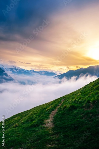 Obraz na płótnie View of a green mountain road with a sea of clouds below the Pyrenees mountains at sunset. Vall d'Aran, catalonia, Spain w salonie