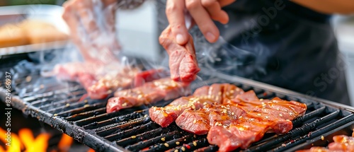 Person grilling marinated meat steaks on a barbecue with flames and smoke in an outdoor setting.