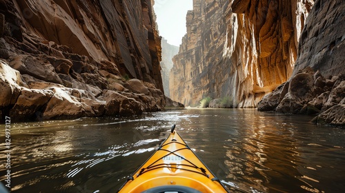A simple kayak being paddled through a narrow canyon photo