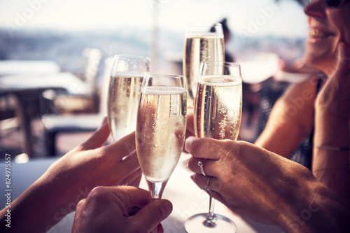 Hands of male and female friends toasting champagne flutes in restaurant photo