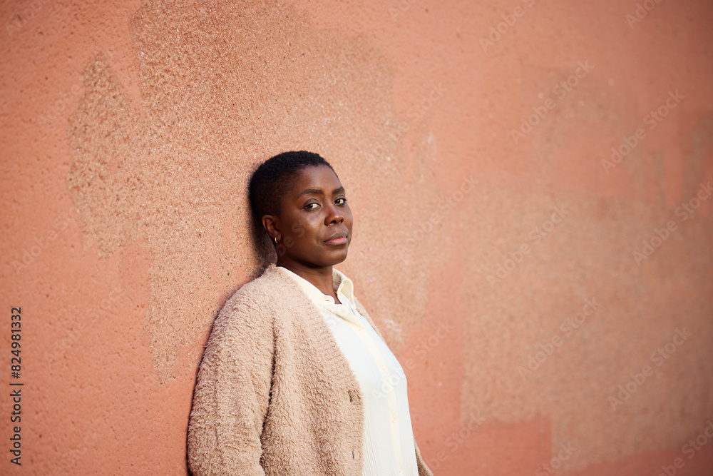 Portrait of mature woman with blank expression standing against wall