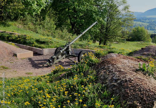 gun position behind wire barriers in trench. anti-tank measures made of metal hedgehogs that get under the belts and reliably stop armored vehicles within mortar range photo