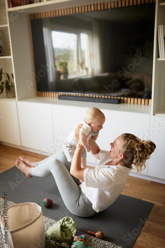 High angle view of mother and son on exercise mat in living room at home photo