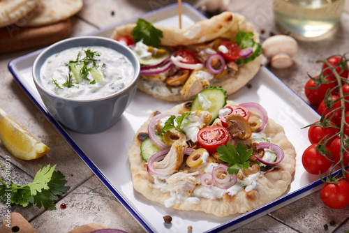 Gyros flatbread filled with chicken meat, tzatziki sauce and vegetables. 